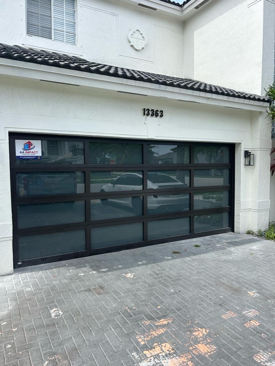 Four-lite impact glass garage door configuration with wide modern glass panels