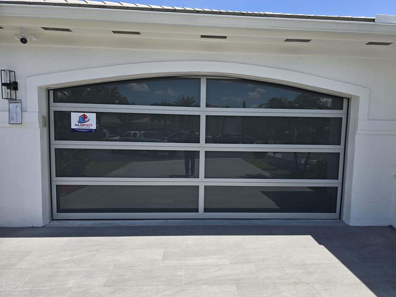 Arched impact glass garage door with curved top frame for a custom luxury look